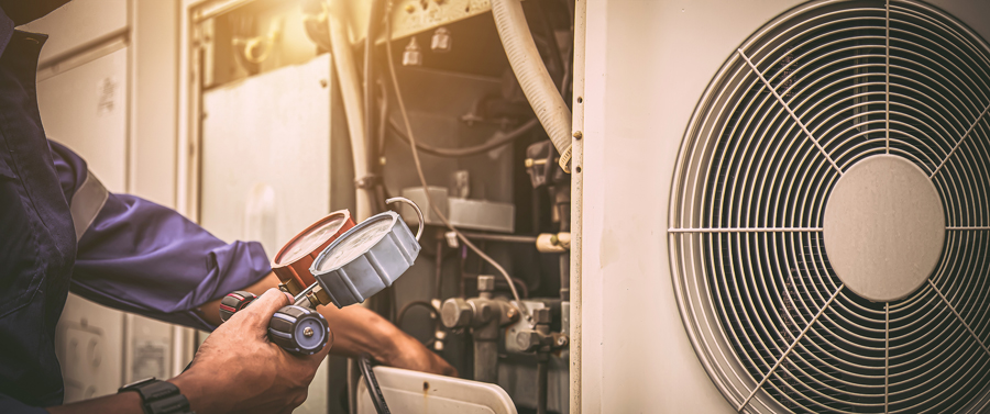 Repairman holding a tool next to an air conditioning unit