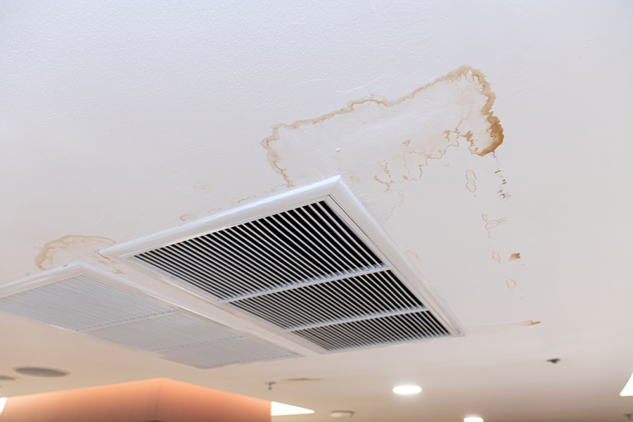 A ceiling fan affected by water damage, evident from the rust and deterioration.