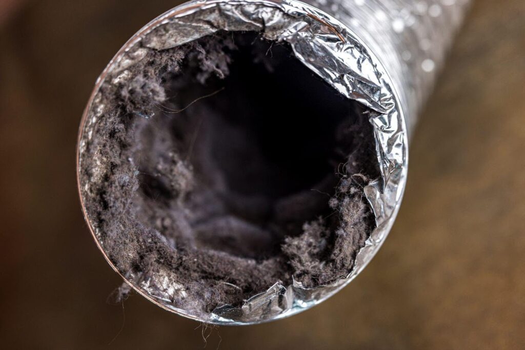 Close-up of a metal pipe partially covered in dirt, highlighting texture