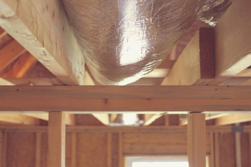 Interior view of a room with visible wood framing and insulation, highlighting the construction details